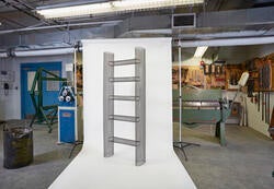 A shelf made of wire being displayed for a photo shoot in a furniture shop